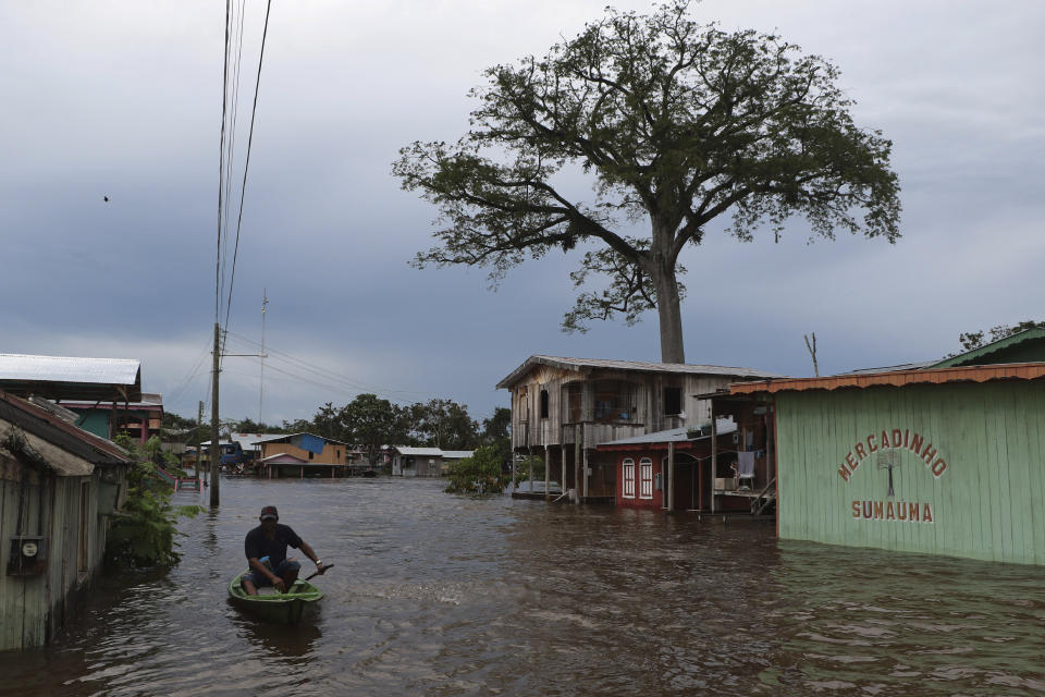 A resident navigates a flooded street in Anama, Amazonas state, Brazil, Thursday, May 13, 2021. (AP Photo/Edmar Barros)