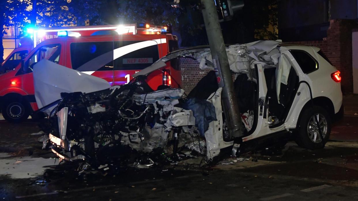 Ein zerstörter Pkw steht an einem Ampelmast in Berlin