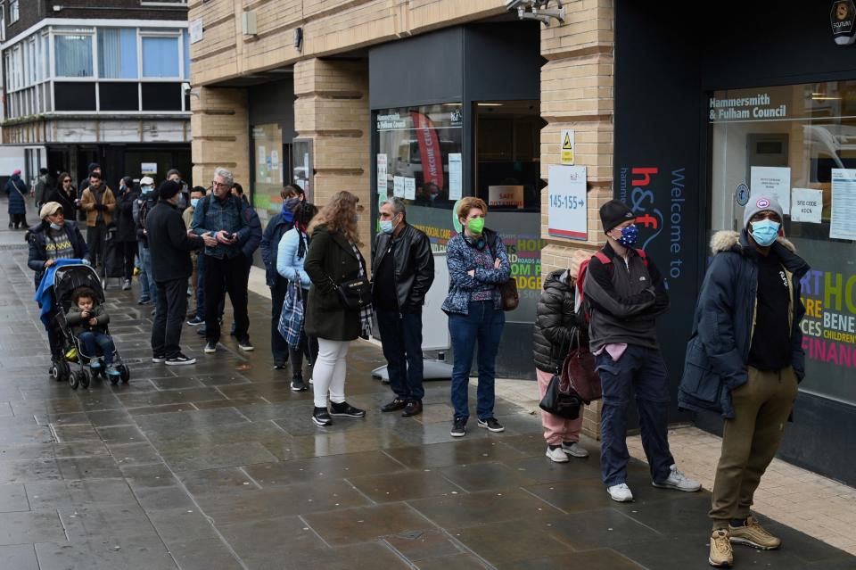 People wait in a queue outside a pop-up vaccination centre for the Covid-19 vaccine or booster, in Hammersmith and Fulham in Greater London on December 3, 2021, as rollout accelerates in England. - Britain has set a two-month target to give booster jabs to all adults over 18, as it seeks to minimise the impact from the Omicron variant of Covid-19. (Photo by Daniel LEAL / AFP) (Photo by DANIEL LEAL/AFP via Getty Images)