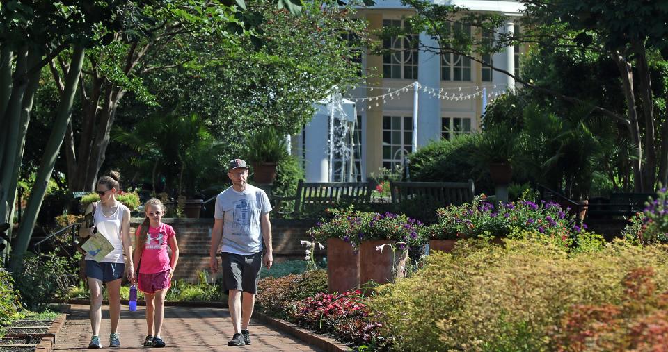 Nine-year-old Anna Elise Toy and her mother, Katy Toy, along with Charlie Cox, walk the grounds of Daniel Stowe Botanical Garden Friday morning, June 17, 2022.