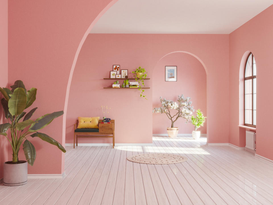 Spare interior scene with a bench, plants, and decorative items on shelves in a room with arched architectural details