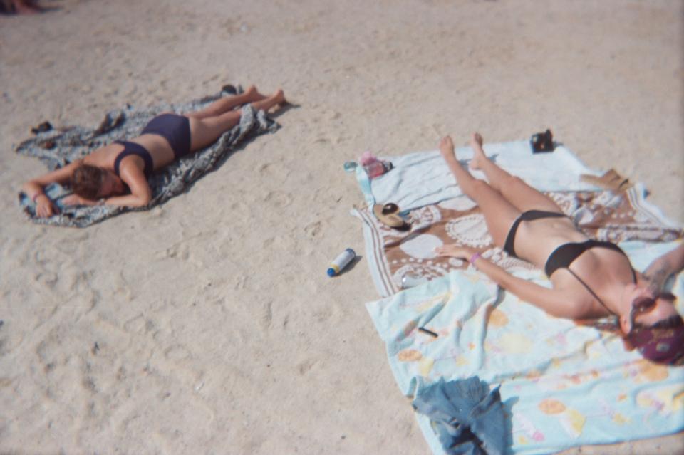 friends laying on a sandy beach