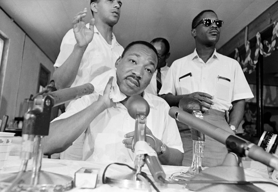 Dr. Martin Luther King, Jr. mops sweat from his neck at a news conference in which he announced future plans for the integration move in St. Augustine, Florida, on June 17, 1964. King remarked, "It's hotter in more ways than one in St. Augustine." (AP Photo)