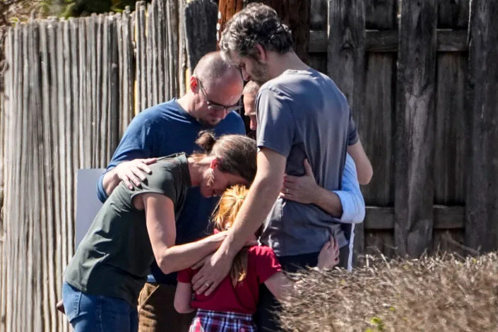 A group prays with a child outside the reunification center at the Woodmont Baptist church after a school shooting, in Nashville, Tenn., this week.