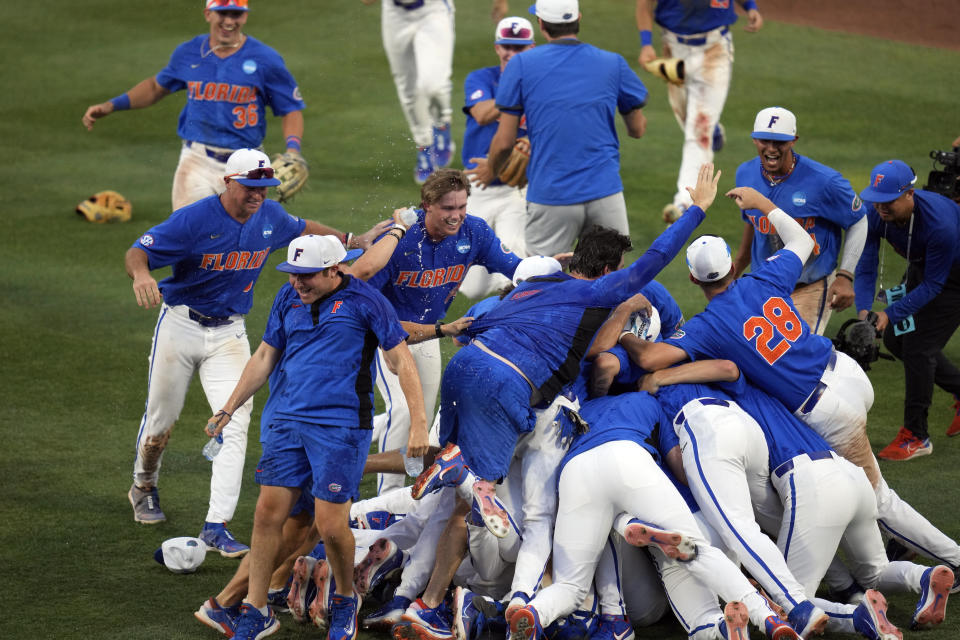 Florida players and coaches celebrate on the field after defeating South Carolina in an NCAA college baseball tournament super regional game Saturday, June 10, 2023, in Gainesville, Fla. (AP Photo/John Raoux)
