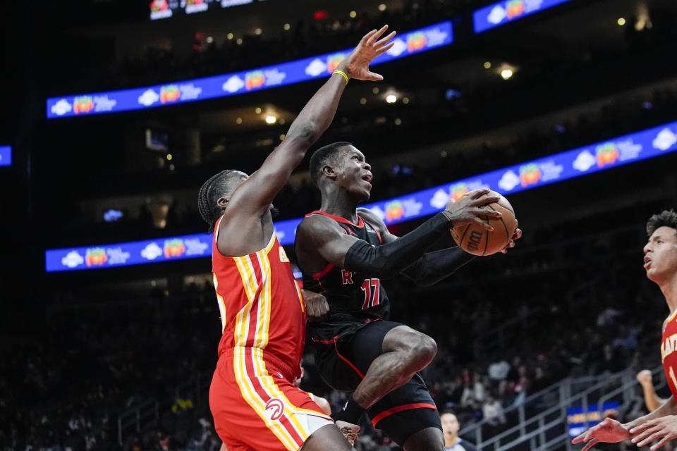 Toronto Raptors guard Dennis Schroder (17) goes up for a shot against Atlanta Hawks center Clint Capela (15) in the first half of an NBA basketball game Sunday, Jan. 28, 2024, in Atlanta. (AP Photo/John Bazemore)