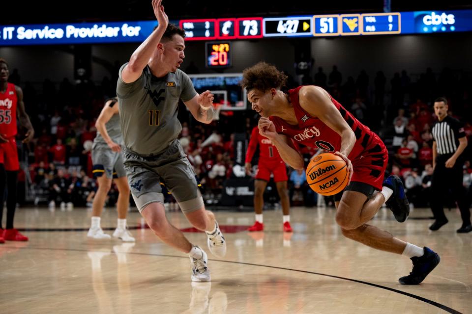 Cincinnati Bearcats guard Dan Skillings Jr. (0) drives on West Virginia Mountaineers forward Quinn Slazinski (11) in their last game on March 9. UC faces West Virginia again in the opening round of the Phillips 66 Big 12 tournament.