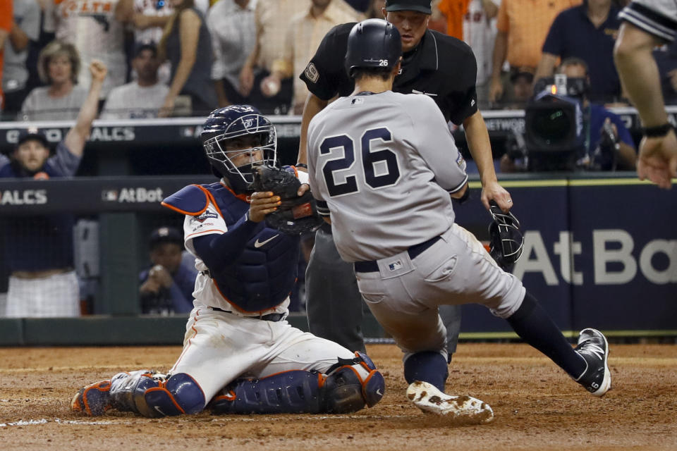 New York Yankees' DJ LeMahieu is tagged out by Houston Astros catcher Robinson Chirinos who tried to score on a single by Brett Gardner during the sixth inning in Game 2 of baseball's American League Championship Series Sunday, Oct. 13, 2019, in Houston. (AP Photo/Eric Gay)