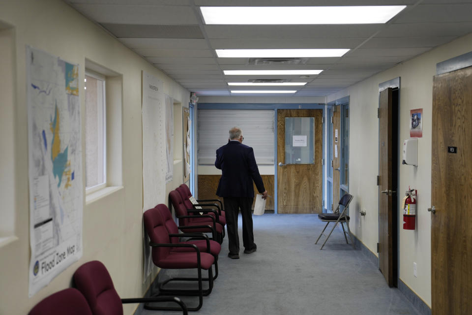 Interim Nye County Clerk Mark Kampf walks down a hallway at an office where early votes are being counted Wednesday, Oct. 26, 2022, in Pahrump, Nev. Ballot counting began in the county where officials citing concerns about voting machine conspiracy theories pressed forward with an unprecedented hand tally of votes cast by mail in advance of Election Day. (AP Photo/John Locher)