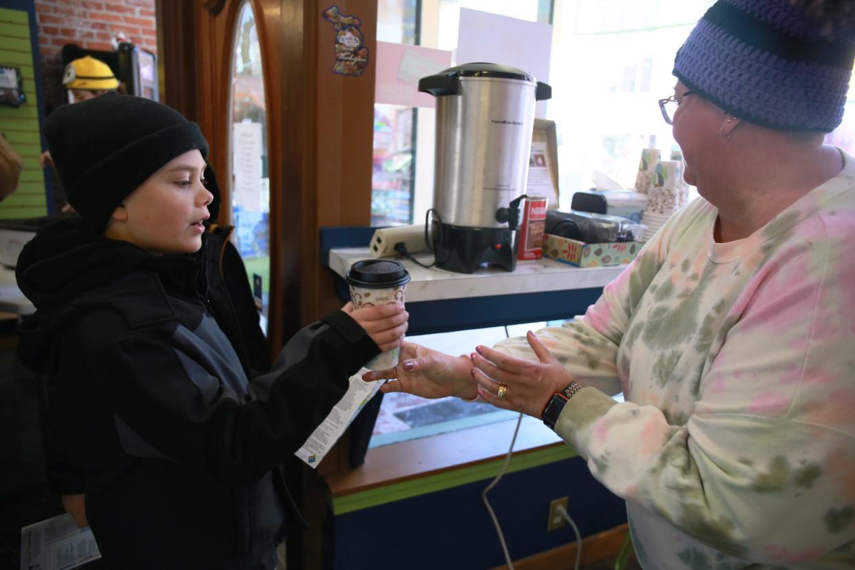 A server at A Little Something hands out hot cocoa to a customer on Saturday, Jan. 29, 2022, during Chilly Fest in downtown Port Huron.