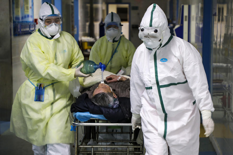 In this Thursday, Feb. 6, 2020, photo, medical workers transfer a patient in the isolation ward for 2019-nCoV patients at a hospital in Wuhan in central China's Hubei province. The number of confirmed cases of the new virus has risen again in China on Saturday, Feb. 8, 2020, as the ruling Communist Party faced anger and recriminations from the public over the death of a doctor who was threatened by police after trying to sound the alarm about the disease over a month ago. (Chinatopix via AP)