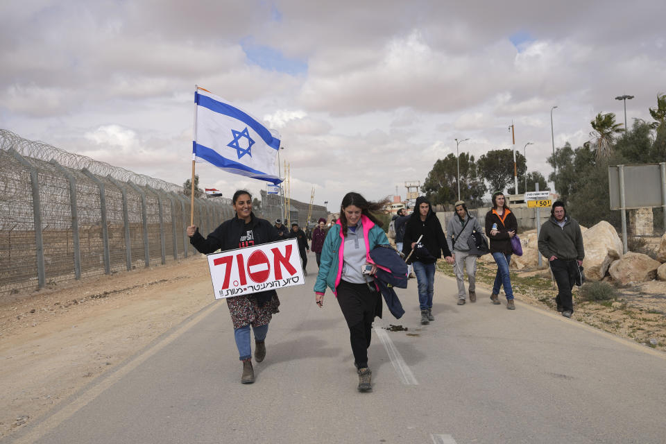 Protesters block the path for humanitarian aid bound for the Gaza Strip at the Nitzana border crossing with Egypt in southern Israel Friday, Feb. 2, 2024. Hebrew placard reads: "Oct. 7 - cannot allow humanitarian aid." (AP Photo/Tsafrir Abayov)