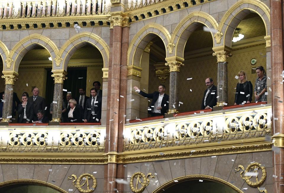 Oppositional lawmakers throw flyers from the balcony at the start of the plenary session of the parliament in Budapest, Hungary, Wednesday, Dec. 12, 2018. (Lajos Soos/MTI via AP)