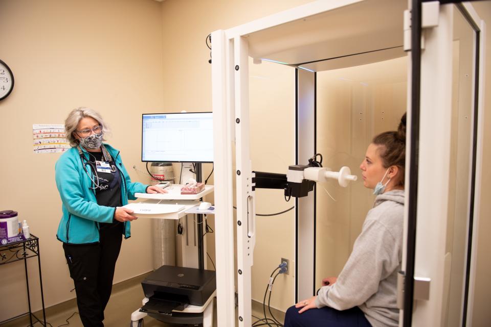 From left, respiratory therapist Layla Bowman and RN Katelyn Boyd demonstrate the spirometer the Benefis Post-COVID-19 Recovery Program uses to measure patients’ lung function and how that changes in response to medication and throughout their course of treatment.