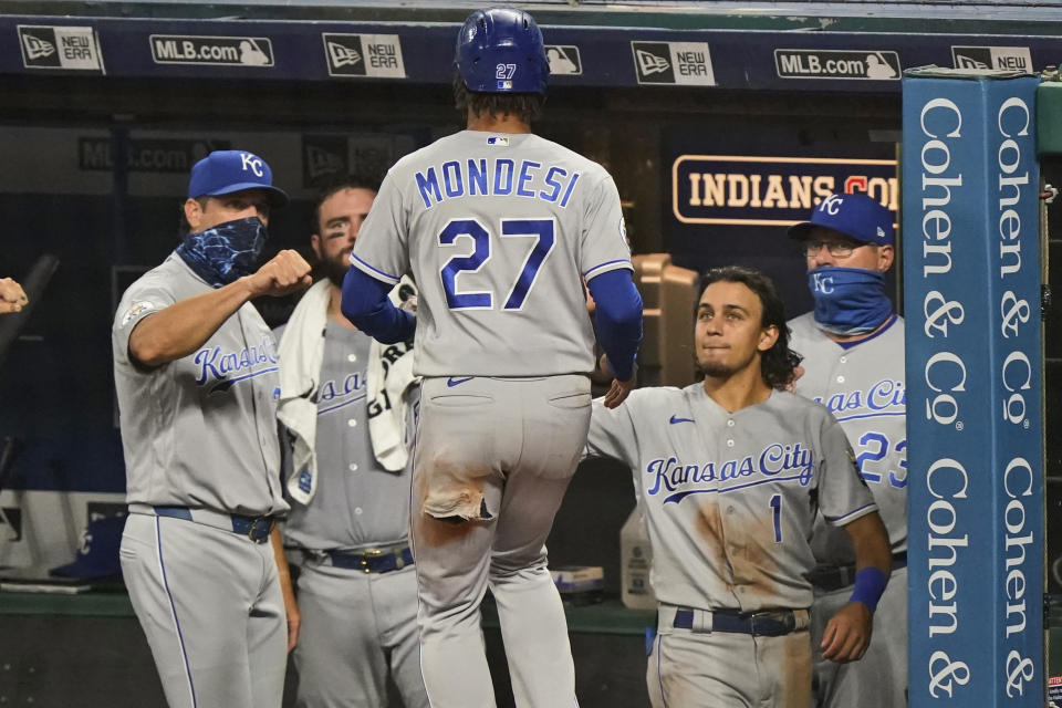 Kansas City Royals' Adalberto Mondesi is congratulated after scoring during the eighth inning of the team's baseball game against the Cleveland Indians, Tuesday, Sept. 8, 2020, in Cleveland. (AP Photo/Tony Dejak)