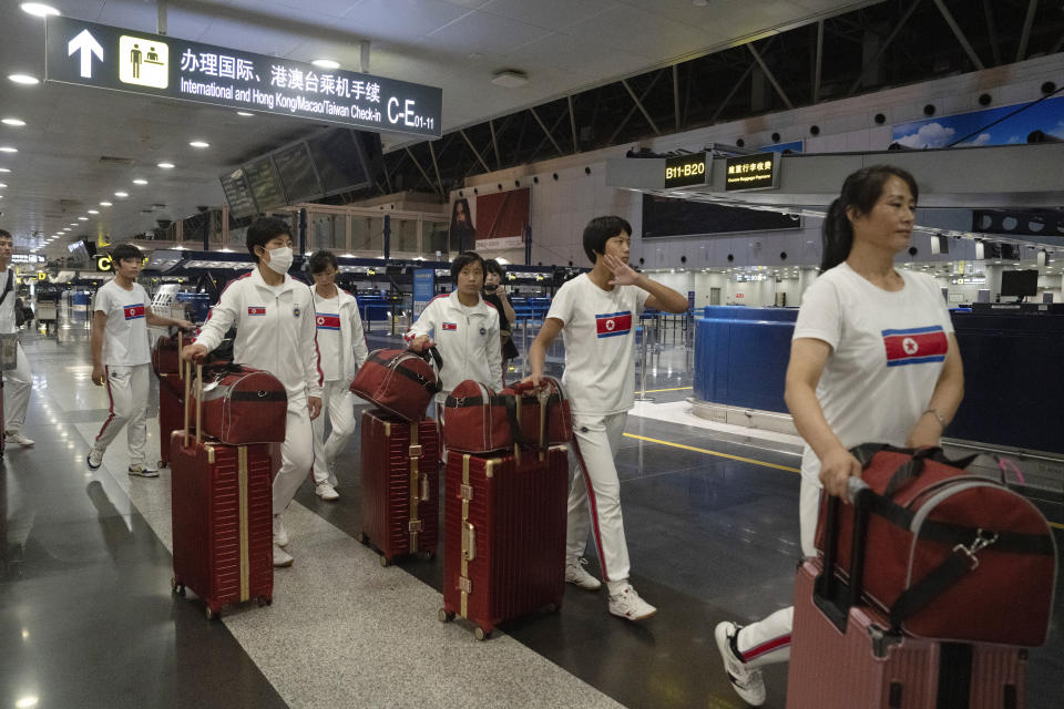 North Korean women wearing track suits with the North Korean flag and the words Taekwon-Do printed on the back walk to check in for a flight to Astana at the Capital Airport in Beijing, Friday, Aug. 18, 2023. A team of North Korean Taekwondo athletes are reportedly travelling via China to Astana, capital of Kazakhstan, to compete in a Taekwondo competition. (AP Photo/Ng Han Guan)