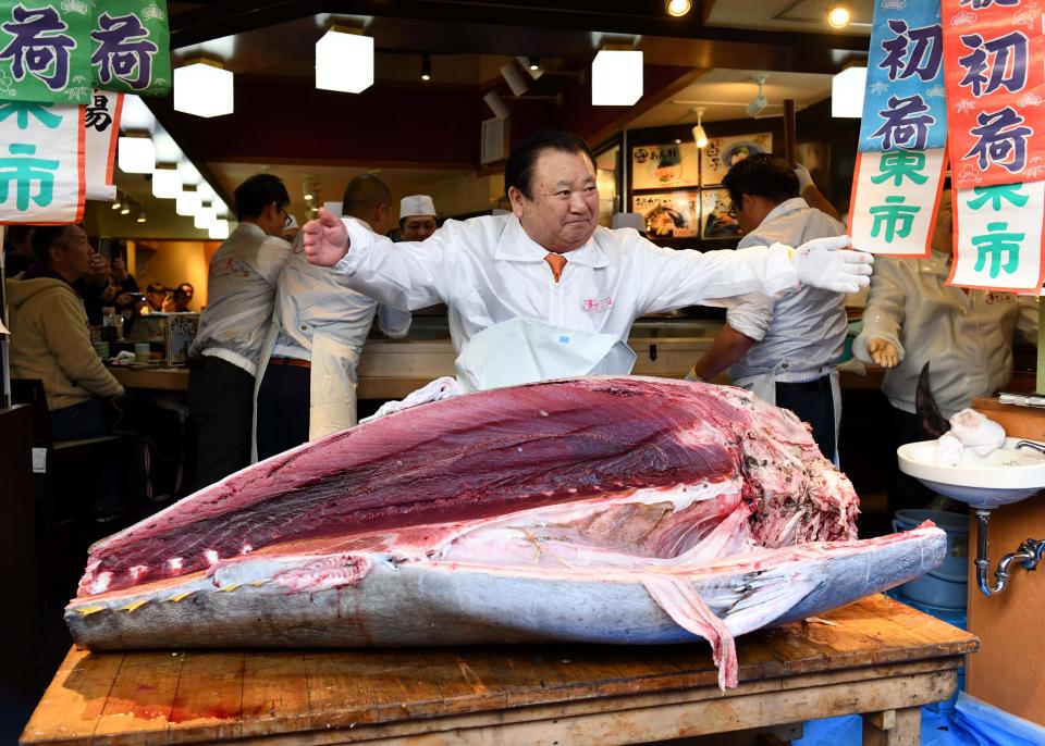 Kiyoshi Kimura (C), president of Kiyomura Corp., the Tokyo-based operator of sushi restaurant chain Sushizanmai, displays a dismantled bluefin tuna the company bought for 193.2 million yen (1.8 million USD) at auction at his main restaurant in Tokyo on January 5, 2020. - Kiyomura Corp. made the winning bid of 1.8 million USD for a 276-kilogram bluefin tuna caught off Oma, Aomori prefecture at the first auction of the year earlier in the day at Tososu fish market. (Photo by Kazuhiro NOGI / AFP) (Photo by KAZUHIRO NOGI/AFP via Getty Images)