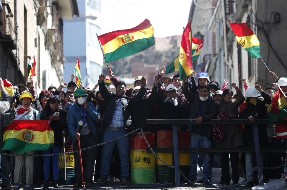 Anti-government protesters against the reelection of President Evo Morales gather just meters away from the presidential palace in La Paz, Bolivia, Saturday, Nov. 9, 2019. Policemen guarding the exteriors of the presidential palace in La Paz retreated to their barracks on Saturday, while officers in other Bolivian cities have declared mutinies and joined protests against Morales, who has faced two weeks of unrest over disputed election results. (AP Photo/Juan Karita)