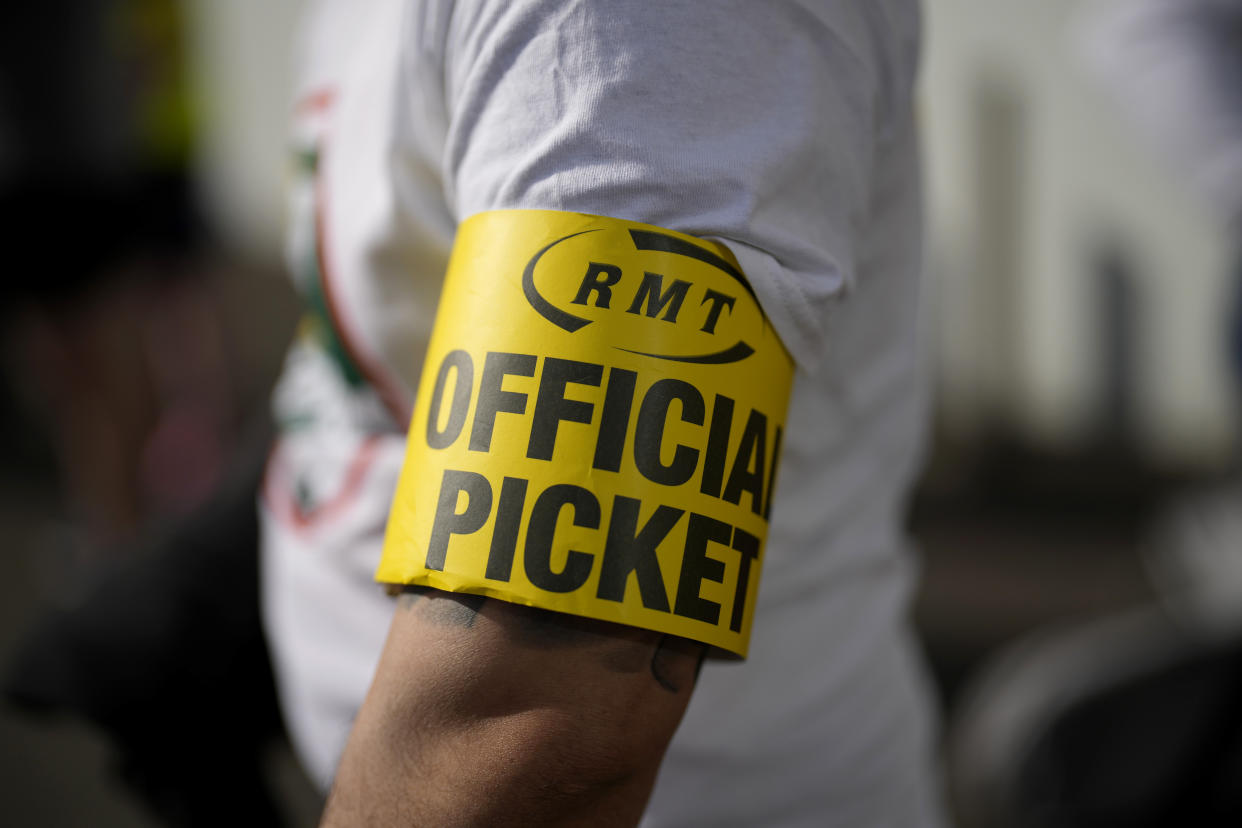 A worker stands on a picket line outside Waterloo railway station, in London, Tuesday, June 21, 2022. Tens of thousands of railway workers walked off the job in Britain on Tuesday, bringing the train network to a crawl in the country’s biggest transit strike for three decades. (AP Photo/Matt Dunham)