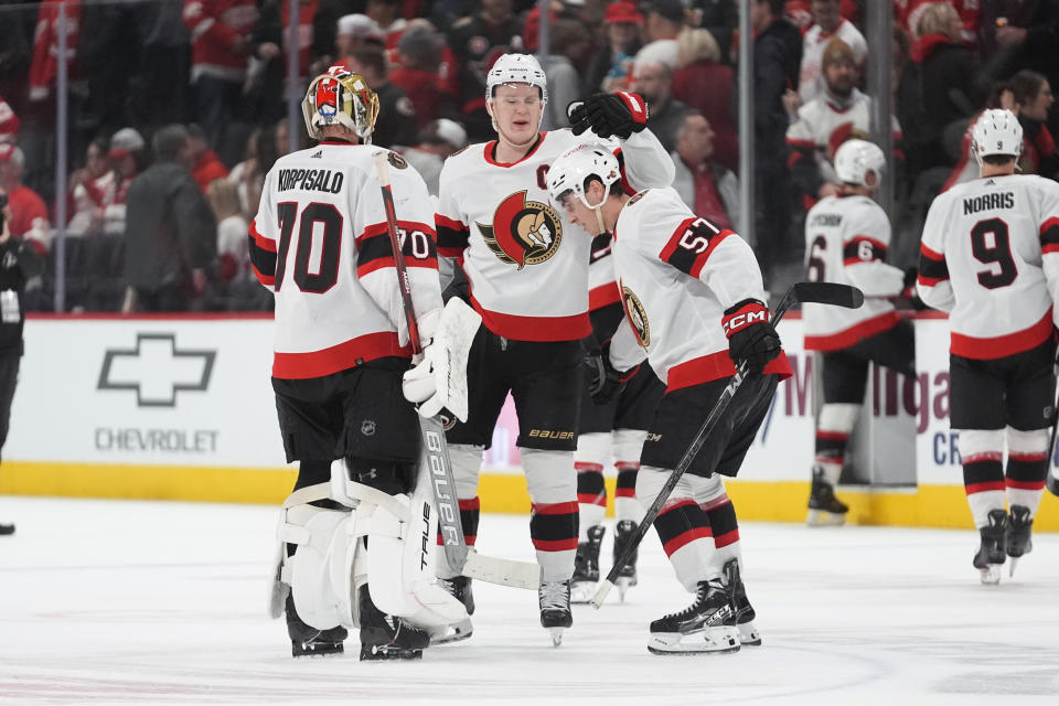 Ottawa Senators center Shane Pinto (57) celebrates with Brady Tkachuk (7) and goaltender Joonas Korpisalo (70) after scoring against the Detroit Red Wings during overtime in an NHL hockey game Wednesday, Jan. 31, 2024, in Detroit. (AP Photo/Paul Sancya)