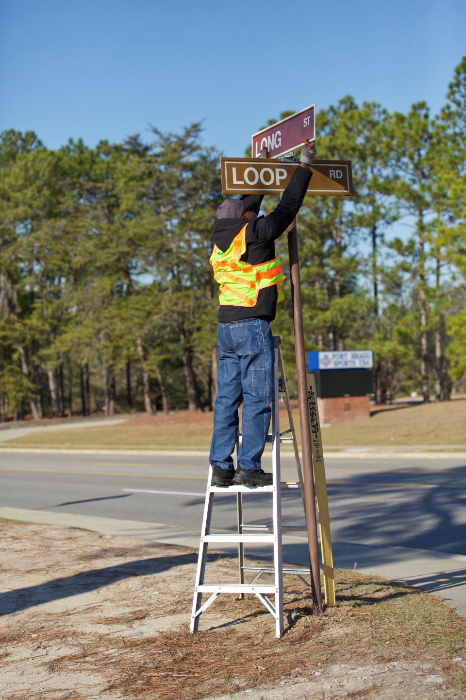 Richard Koonce, an employee for Fort Bragg Directorate of Public Works, installs the new street sign signifying the name change of Long Street on Jan. 14, 2022.