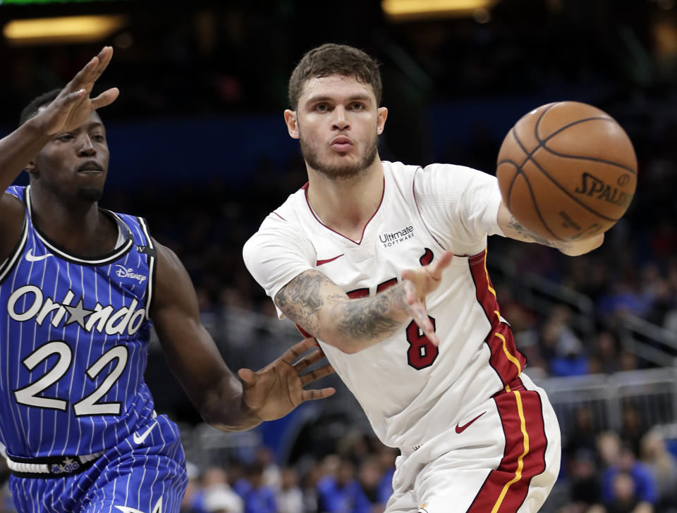 Miami Heat's Tyler Johnson (8) passes the ball as he is defended by Orlando Magic's Jerian Grant (22) during the first half of an NBA basketball game, Sunday, Dec. 23, 2018, in Orlando, Fla. (AP Photo/John Raoux)