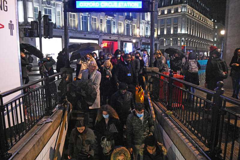 People enter Oxford Circus underground station in London after the 10pm curfew that pubs and restaurants are subject to in order to combat the rise in coronavirus cases in England.