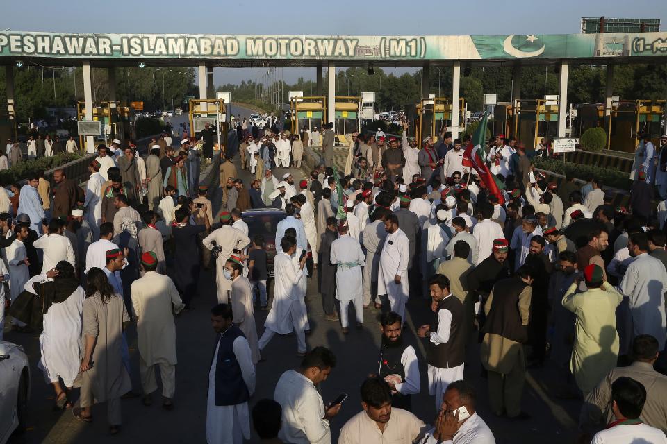 Supporters of former Prime Minister Imran Khan's party block a highway during a protest to condemn Election Commission's decision, in Peshawar, Pakistan, Friday, Oct. 21, 2022. Pakistan's elections commission on Friday disqualified former Prime Minister Imran Khan from holding public office for five years, accusing him of unlawfully selling state gifts and concealing assets, his spokesman and officials said. The move is likely to deepen lingering political turmoil in the impoverished country. (AP Photo/Muhammad Sajjad)