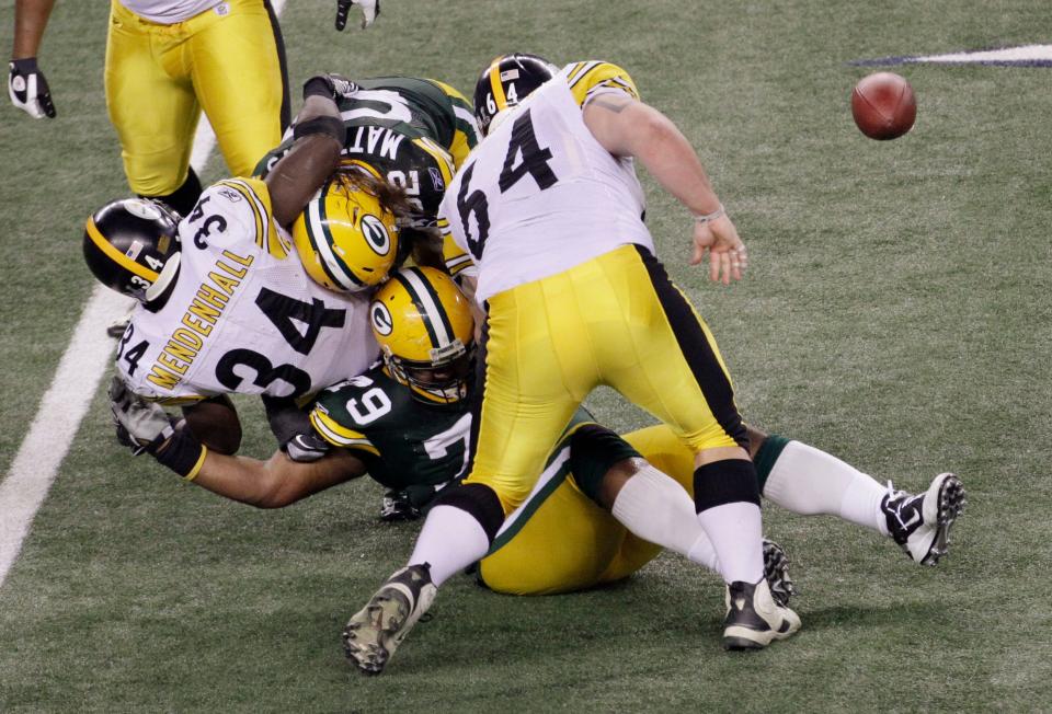 Green Bay Packers defenders Clay Matthews and Ryan Pickett (79) force a fumble by Pittsburgh Steelers running back Rashard Mendenhall (34) in the second half of Super Bowl XLV in Arlington, Texas, on Sunday, Feb. 6, 2011.