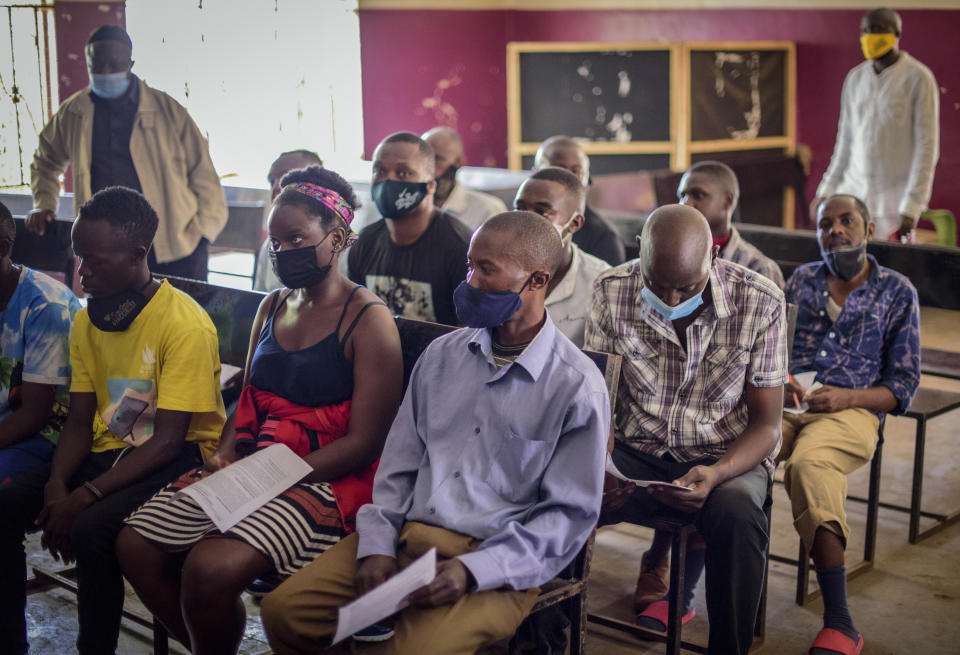 People wait to receive coronavirus vaccinations at Kisenyi Health Center in downtown Kampala, Uganda Wednesday, Sept. 8, 2021. Uganda is accelerating its vaccination drive in order to administer 128,000 doses that recently arrived and expire at the end of September. (AP Photo/Nicholas Bamulanzeki)