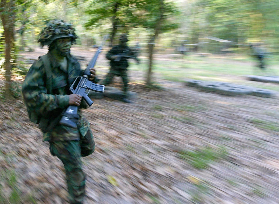 A recruit dashes across a field during training at Pulau Tekong. 