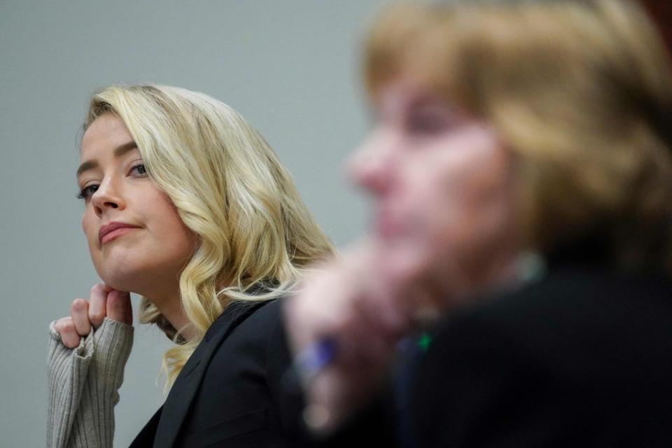 Amber Heard listens, next to her lawyer Elaine Bredehoft, as her sister is questioned (POOL/AFP via Getty Images)