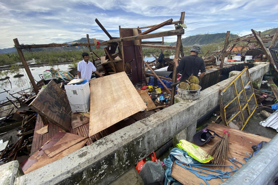 Residents salvage what's left of their belongings at their damaged home due to Typhoon Rai in Surigao city, Surigao del Norte, central Philippines on Friday Dec. 17, 2021. A powerful typhoon left more than a dozen people dead, knocked down power and communications in entire provinces and wrought widespread destruction mostly in the central Philippines, officials said Saturday. (AP Photo/Erwin Mascarinas)