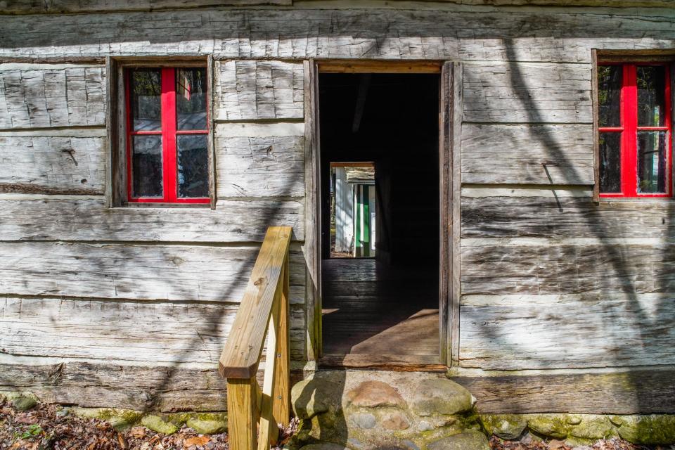 A wooden cabin with red windows