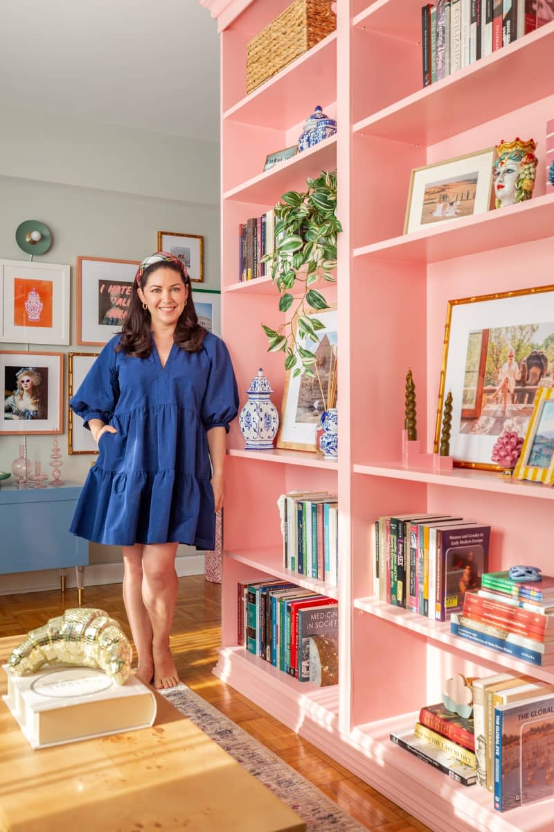 Dweller poses next to a large pink shelving unit.