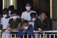 Migrants wait to disembark the ship 'Geo Barents' after week waiting at sea, in Augusta