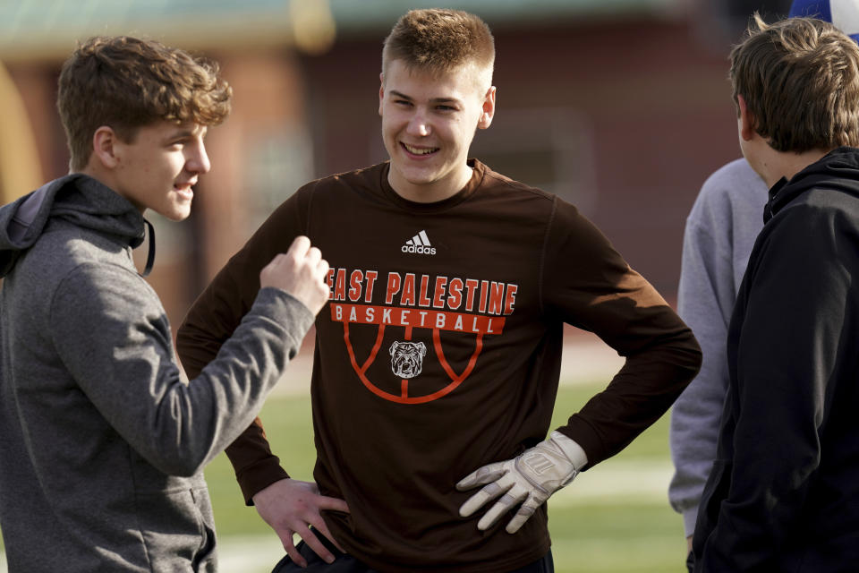 East Palestine High School senior Owen Elliott, center, talks with baseball teammates during practice, Monday, March 6, 2023, in East Palestine, Ohio. Athletes are navigating spring sports following the Feb. 3 Norfolk Southern freight train derailment. (AP Photo/Matt Freed)