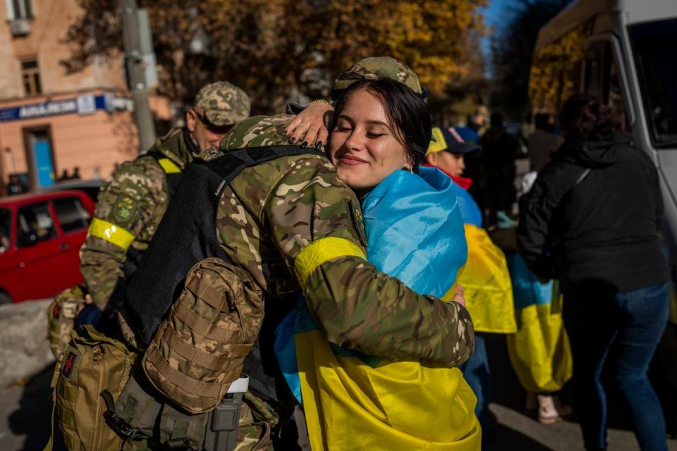 A Kherson resident hugs a Ukrainian defence force member on Monday, November 14 (AP)
