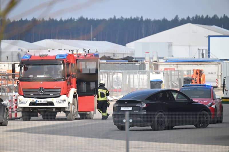 Firefighters work on the site of the Tesla car factory in Gruenheide, where production has come to a standstill due to a power outage. The factory in Gruenheide near Berlin has been evacuated, a spokeswoman said. Sebastian Gollnow/dpa
