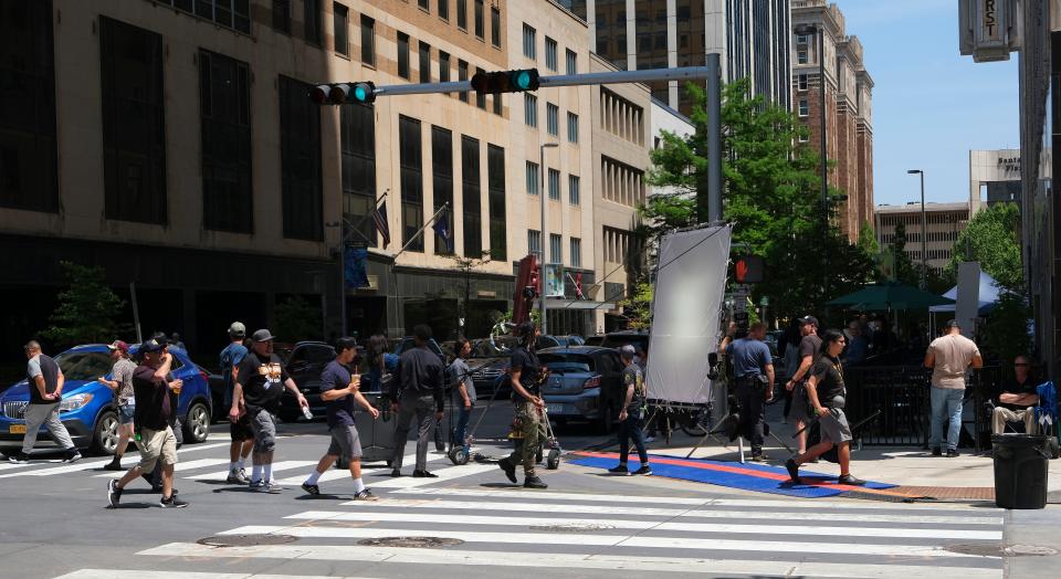 Extras walk back and forth May 9 on the sidewalk of Park Avenue as background for a scene while crews work on filming the movie "Twisters" in downtown Oklahoma City.