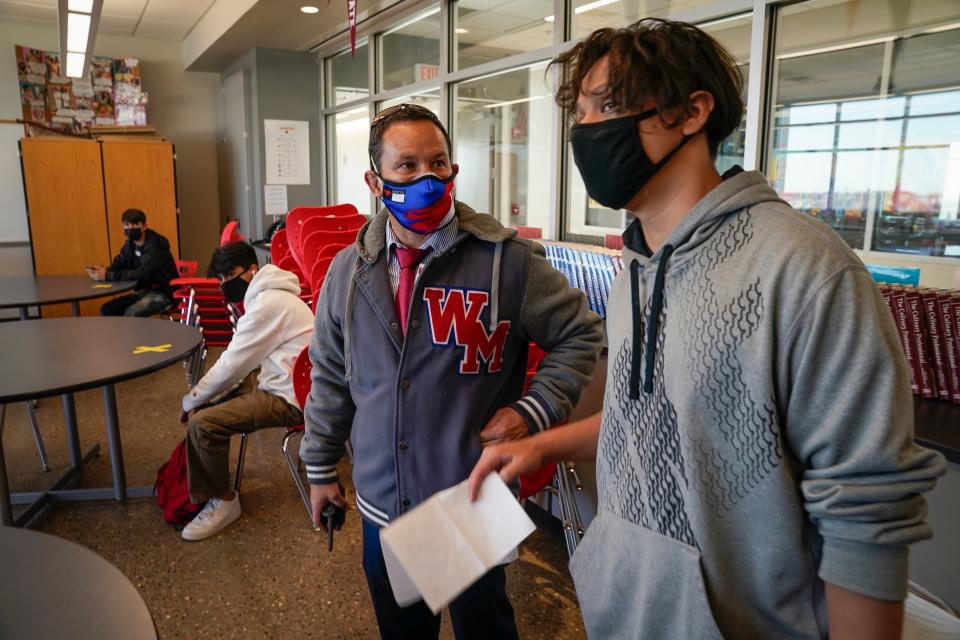 West Mesa High School principal Mark Garcia welcomes students and staff to campus as students return to school.