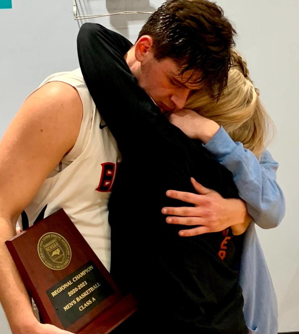 Carter Seitz (in uniform) hugs his mother Liz Seitz and his sister, Peyton Seitz, after Lincoln Charter won the 1A Western Regional Final over Mount Airy on Tuesday. Lincoln Charter advanced to the state final Saturday against Wilson Prep with the victory.