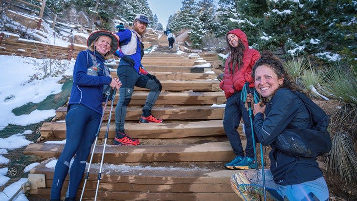 A group of hikers smile as they climb the Manitou Incline