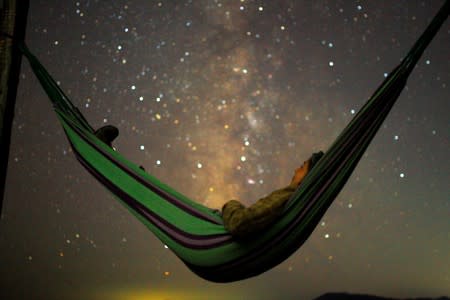 FILE PHOTO: A girl lies in hammock as she looks at the milky way during the peak of Perseid meteor shower in Kozjak