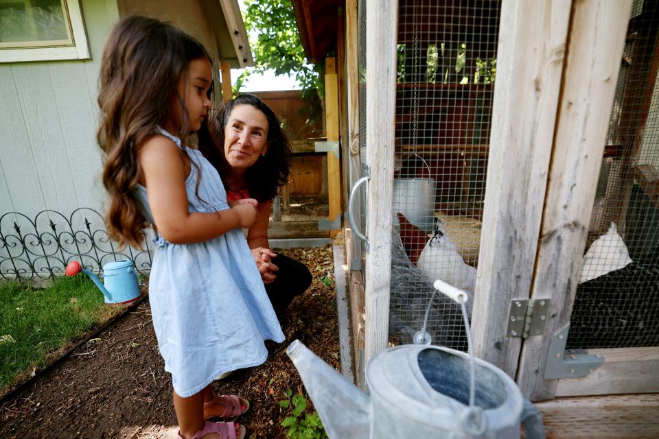 Dr. Bonnie Feola talks with Mila Gill about her chickens as Mila and her family visit Feola’s Salt Lake City home on Wednesday, July 26, 2023. Feola works with kids and parents on learning about eating healthy and how to prepare food. | Scott G Winterton, Deseret News