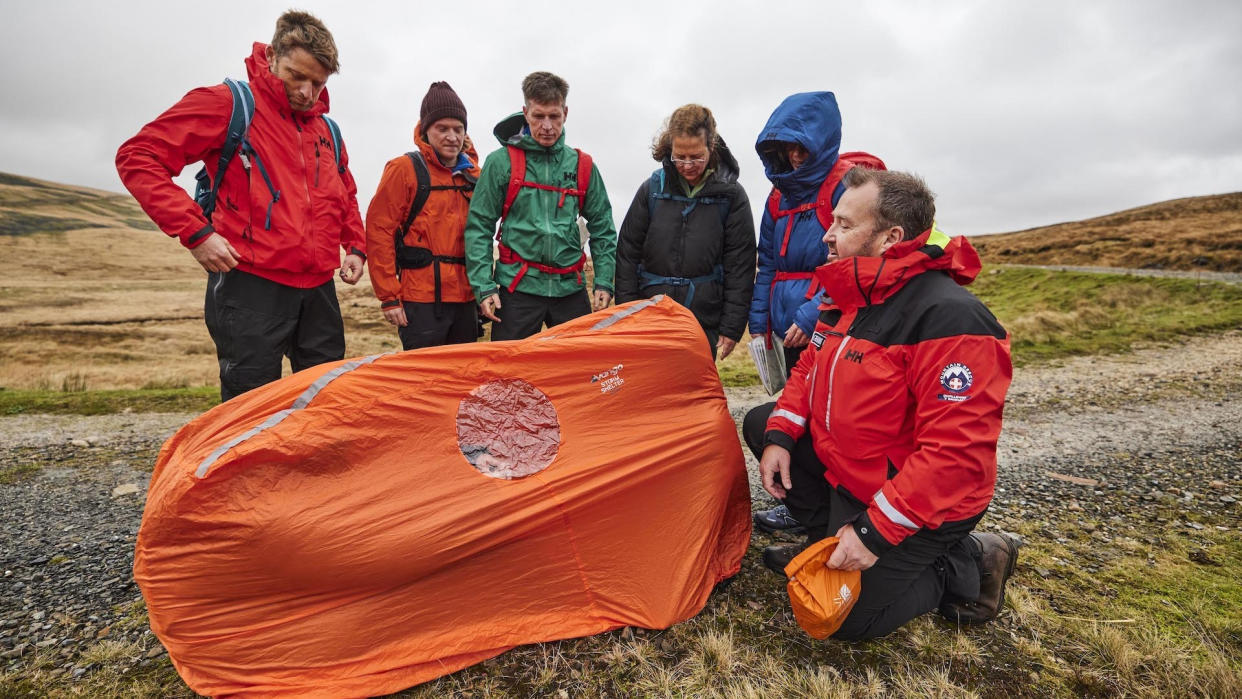  A guided group take a look at at small, two-person survival shelter. 