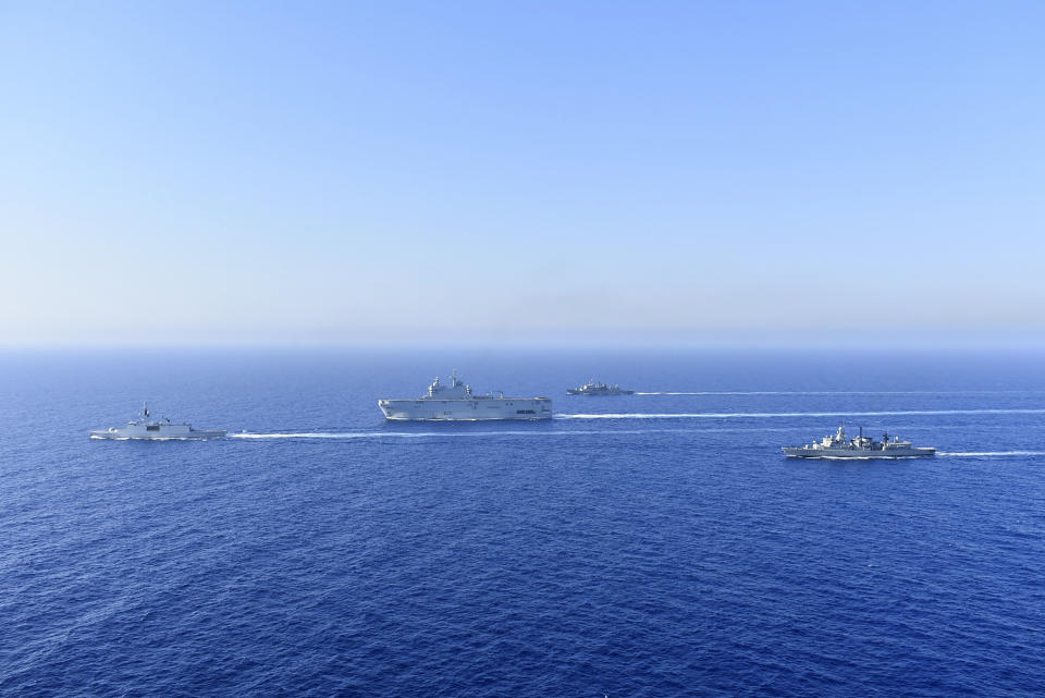 In this photo provided by the Greek National Defence, a French Tonnerre helicopter carrier, center, and French Lafayette frigate, left, are escorted by Greek and French military vessels during a maritime exercise in the Eastern Mediterranean, Thursday, Aug. 13, 2020. Greece's prime minister warmly thanked France Thursday for its decision to boost its military presence in the eastern Mediterranean, where Greek and Turkish warships are closely shadowing each other over a Turkish energy exploration bid in waters Athens claims as its own. (Greek National Defence via AP)