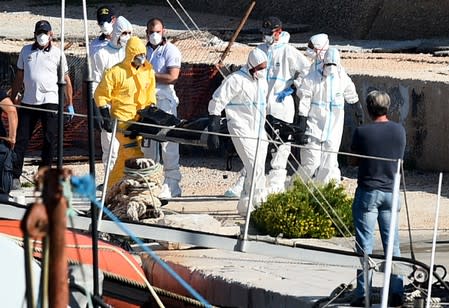 Emergency services carry bodies from a migrant shipwreck that took place on October 7 back to the island of Lampedusa