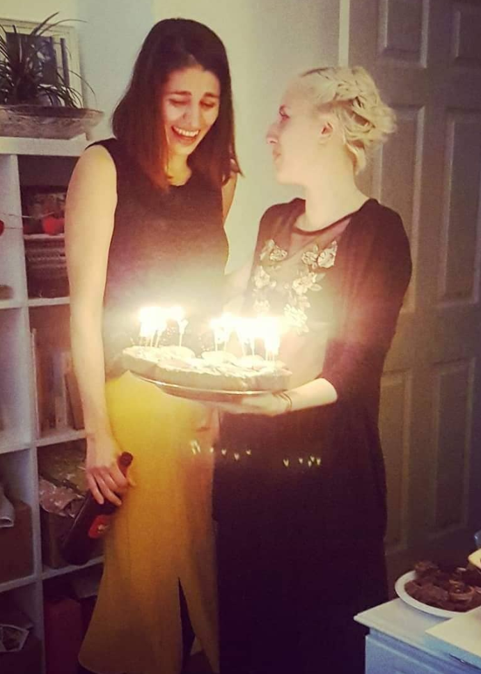 Photo of woman reacting after being gifted cake with Marie Curie rather than Mariah Carey. 