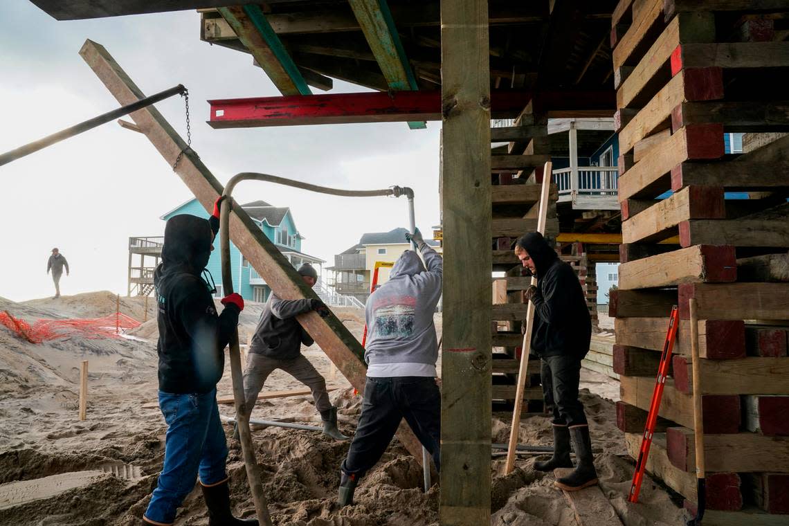 Crew works to stabilize Cindy Doughty’s South Shore Drive home in Rodanthe, North Carolina, after it was moved inland from its original location.